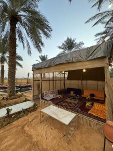 a tent in the desert with a palm tree at منتجع الرتاج الريفي in Buraydah