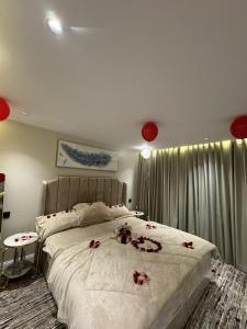 a bedroom with a large bed with roses on it at منتجع الرتاج الريفي in Buraydah