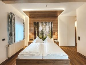 una camera da letto con un grande letto con cuscini bianchi di Hotel Badischer Hof a Biberach bei Offenburg