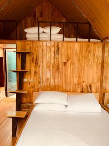 1 dormitorio con 1 cama en una pared de madera en Homestay Suối Khoáng Minh Hằng, en Yên Bái