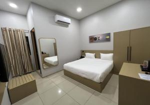 金沙萨Ixoras Hotel Victoire的一间带床和镜子的酒店房间