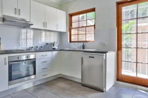 een keuken met witte kasten en een vaatwasser bij Elegant House Chippendale - City Center 2 E-Bikes Included in Sydney