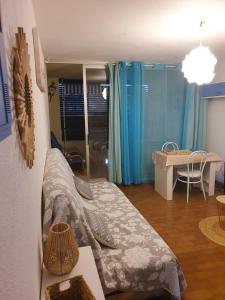Zimmer mit einem Bett und einem Tisch in einem Zimmer in der Unterkunft Agréable Studio Cabine - piscine - parking - proche Plage RICHELIEU in Cap d'Agde