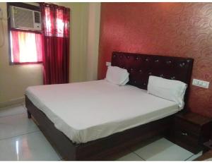 a bed in a room with a red wall at Hotel Sun Park, Chandigarh in Chandīgarh