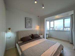 a bedroom with a large bed and a large window at Four-Bedroom Apartment, The Bund View with Branded Appliances in Shanghai