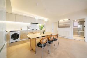 a kitchen with a wooden table and chairs at Four-Bedroom Apartment, The Bund View with Branded Appliances in Shanghai