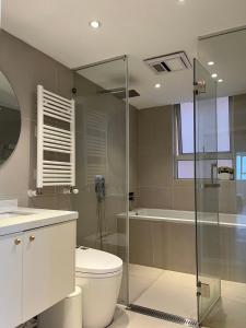 a bathroom with a toilet and a glass shower at Four-Bedroom Apartment, The Bund View with Branded Appliances in Shanghai