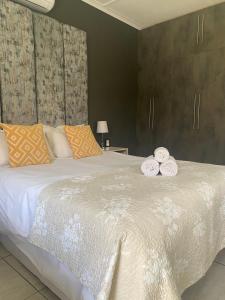 a bedroom with a large bed with two towels on it at La Benroy in Klerksdorp