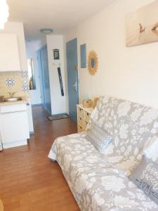 ein Wohnzimmer mit einem Sofa und einer Küche in der Unterkunft Agréable Studio Cabine - piscine - parking - proche Plage RICHELIEU in Cap d'Agde