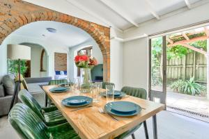 a dining room with a wooden table with blue plates at Comfortable 2 Bedroom House Paddington 2 E-Bikes Included in Sydney