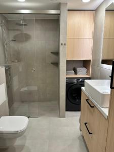 ein Bad mit einer Dusche, einem WC und einem Waschbecken in der Unterkunft Riia 22 Apartment in Tartu