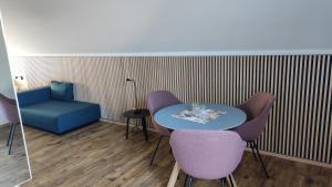 um quarto com uma mesa e cadeiras e uma cadeira azul em Gasthof Hasen em Berg bei Ravensburg