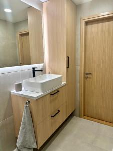 ein Badezimmer mit einem weißen Waschbecken und einem Spiegel in der Unterkunft Riia 22 Apartment in Tartu