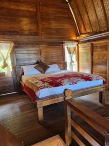 a bedroom with a bed in a wooden room at Baruna Cottages in Kintamani