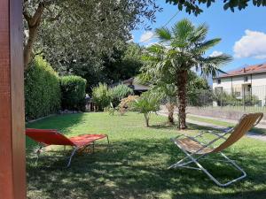 two chairs sitting in the grass in a yard at Casa Luce e Aria in Colico