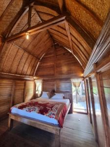 a bed in a room with a wooden ceiling at Baruna Cottages in Kintamani