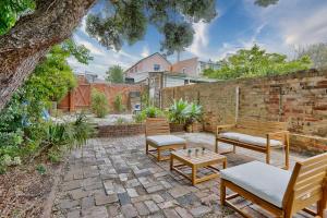 a patio with benches and a brick wall at Comfortable 2 Bedroom House Paddington 2 E-Bikes Included in Sydney
