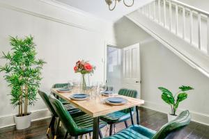 a dining room with a table and green chairs at 2 Bedroom House Darling Harbour Kent St in Sydney
