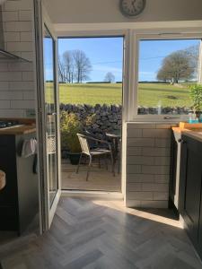 a kitchen with a door open to a patio at Primrose Cottage - Tideswell, Peak District in Tideswell