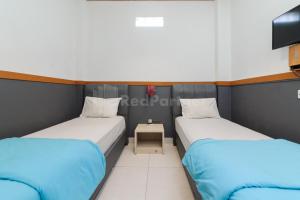 Letto o letti in una camera di Ian Hotel Jaksa Mitra RedDoorz