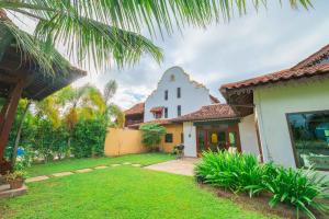 a person standing in a yard in front of a house at Limasan Villa Langkawi in Pantai Cenang