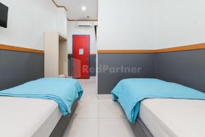 Letto o letti in una camera di Ian Hotel Jaksa Mitra RedDoorz