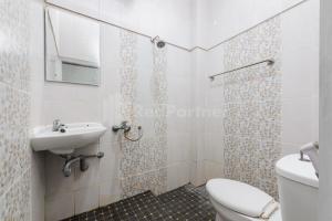 un bagno con un water e un lavandino di Ian Hotel Jaksa Mitra RedDoorz a Giacarta