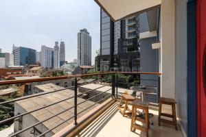 balcón con 2 sillas y vistas a la ciudad en Ian Hotel Jaksa Mitra RedDoorz en Yakarta