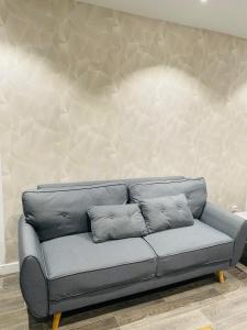 um sofá cinzento num quarto com uma parede em Studio cosy 