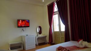 a bedroom with a bed and a television on the wall at Pho Hoi 1 Hotel in Hoi An