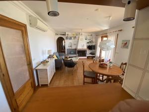 a living room with a table and a dining room at Villa GALERA in Son Bou