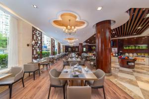 a restaurant with tables and chairs and a chandelier at Binbei Yiho Hotel in Xiamen