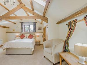 a bedroom with a bed and a chair at 3 Bed in Bude BBARN in Sutcombe
