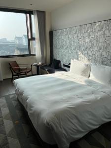 a large white bed in a room with a large window at Jiangnan House Guanqianjie in Suzhou