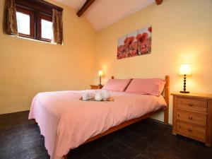 ein Schlafzimmer mit einem Bett mit zwei Tassen drauf in der Unterkunft 3 Bed in Ilfracombe GRAIC in West Down