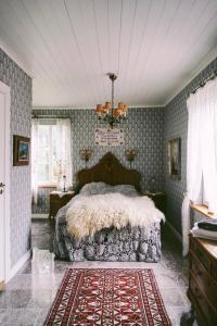 a bedroom with a bed in a room with wallpaper at Åkerbo gård charmigt renoverad flygel in Kristinehamn