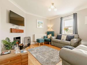 a living room with a couch and a tv at 3 Bed in Newquay TREOC in Mawgan Porth