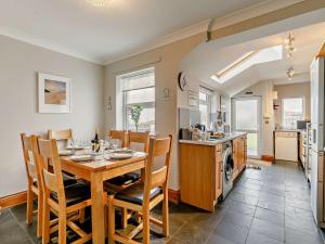 a kitchen and dining room with a table and chairs at 3 Bed in Newquay TREOC in Mawgan Porth