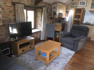 a living room with a tv and a couch and a table at 1 Bed in Dawlish Warren WARRE in Cockwood