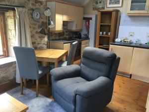 a living room with a table and a chair and a kitchen at 1 Bed in Dawlish Warren WARRE in Cockwood
