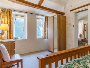 a bedroom with a bed and a chair and windows at 1 Bed in Bigbury-on-Sea 05069 in Woodleigh