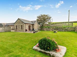 a stone house with a green yard with a stone wall at 1 Bed in Helston BODER in Wendron