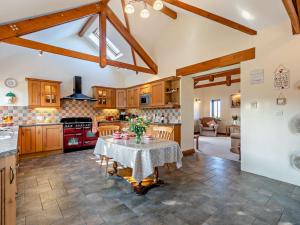 a kitchen and living room with a table with flowers on it at 1 Bed in Helston BODER in Wendron