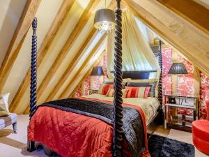 ein Schlafzimmer mit einem Himmelbett im Dachgeschoss in der Unterkunft 1 Bed in Bicester Village CLEAR in Ludgershall