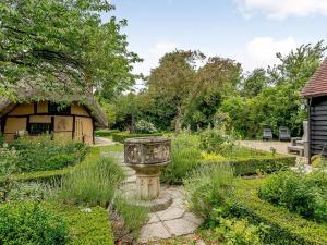 einen Garten mit einem Steinpflanzer in der Mitte in der Unterkunft 1 Bed in Bicester Village CLEAR in Ludgershall