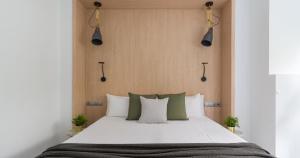 1 dormitorio con 1 cama grande con almohadas blancas y verdes en Tusity One, en Las Palmas de Gran Canaria