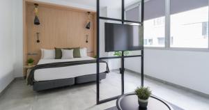 1 dormitorio con 1 cama y TV de pantalla plana en Tusity One, en Las Palmas de Gran Canaria