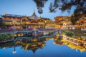 un edificio con un reflejo en el agua por la noche en Pudong Shangri-La, Shanghai, en Shanghái