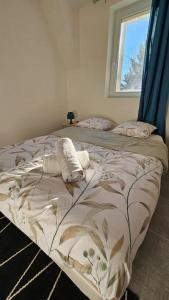 - un lit dans une chambre avec fenêtre dans l'établissement La Grande Ourse - Wifi - Terrasse - Vulcania, à Saint-Ours