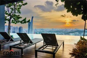 2 stoelen op een balkon met uitzicht op de stad bij ViiA Residences Kuala Lumpur in Kuala Lumpur